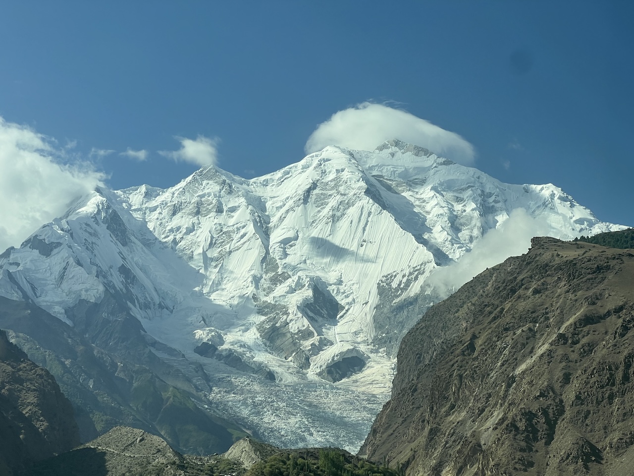 Altissime cime Pakistan del nord Enorme montagna innevata con un ghiacciaio visibile, una vetta molto alta, circondata da cime e vallate rocciose