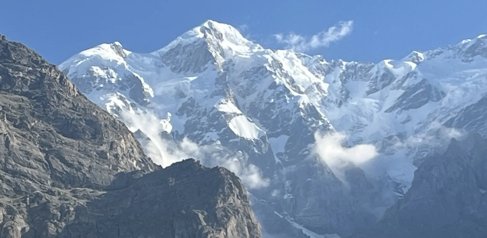 Vista ravvicinata di una maestosa montagna, con la cima completamente innevata e rocce scure in primo piano