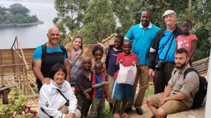 Foto gruppo turisti occidentali con famiglia ugandese