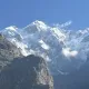 Vista ravvicinata di una maestosa montagna, con la cima completamente innevata e rocce scure in primo piano